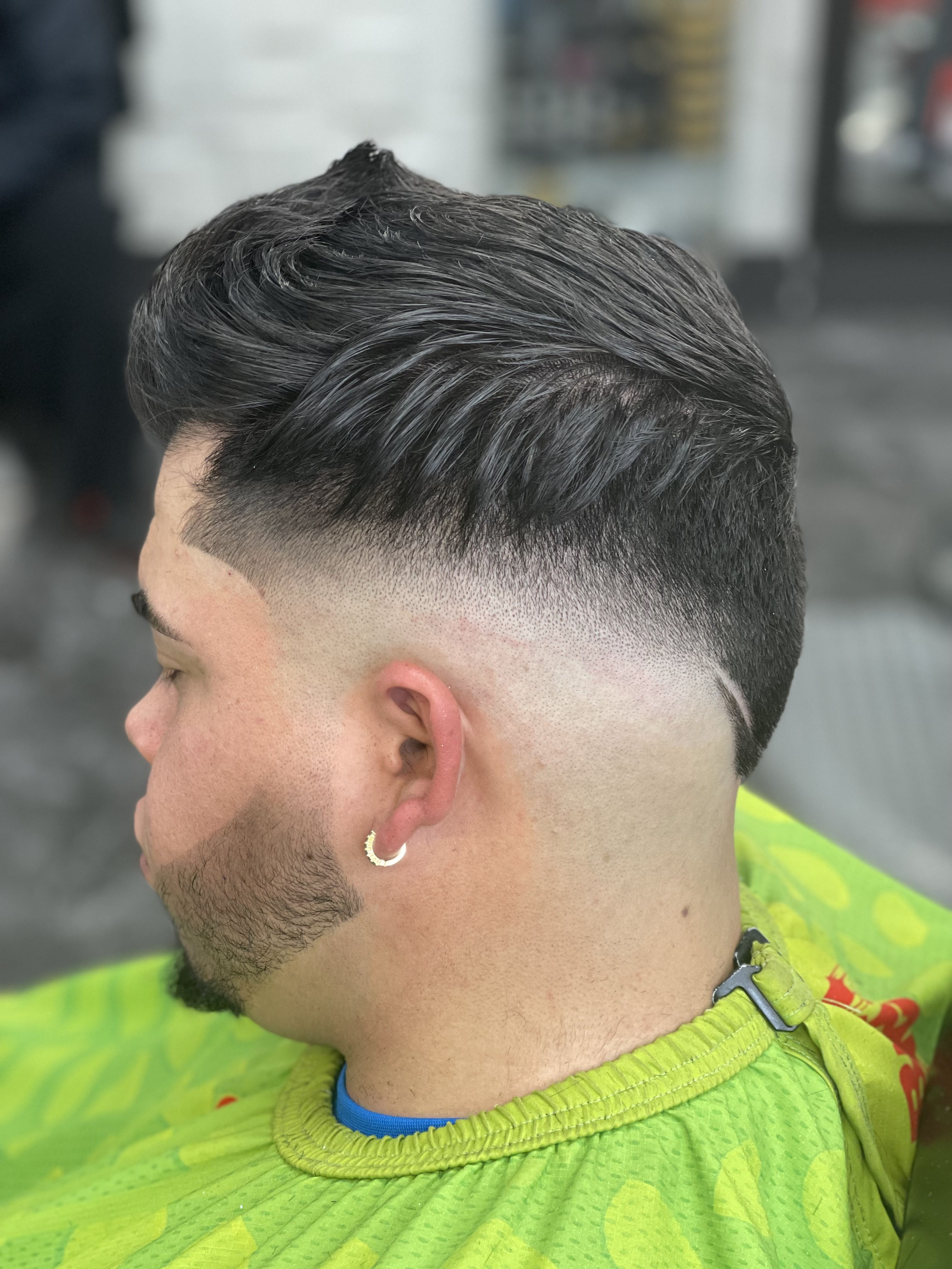 Clean mid fade with textured top and beard lineup